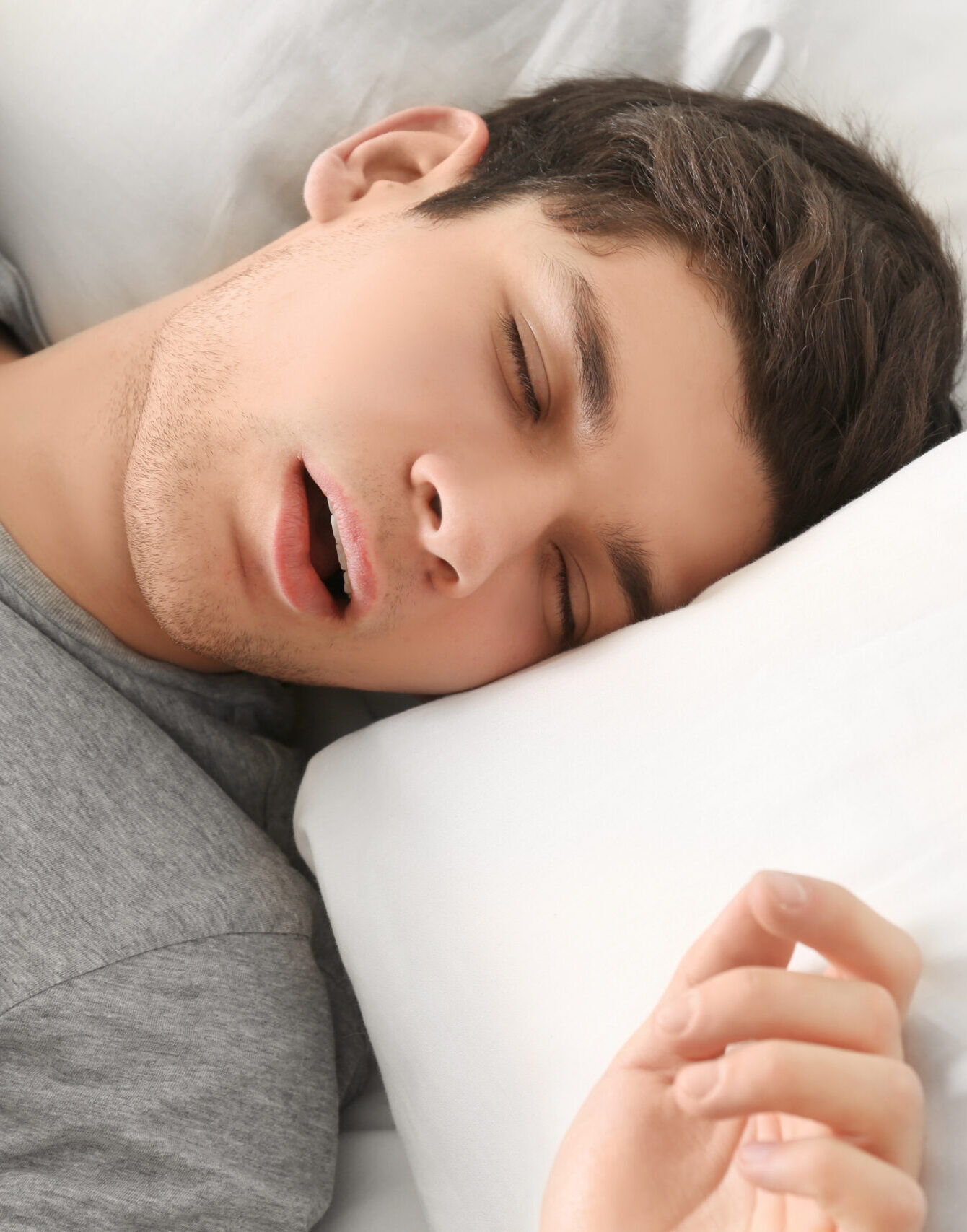 Handsome young man sleeping in bed at home
