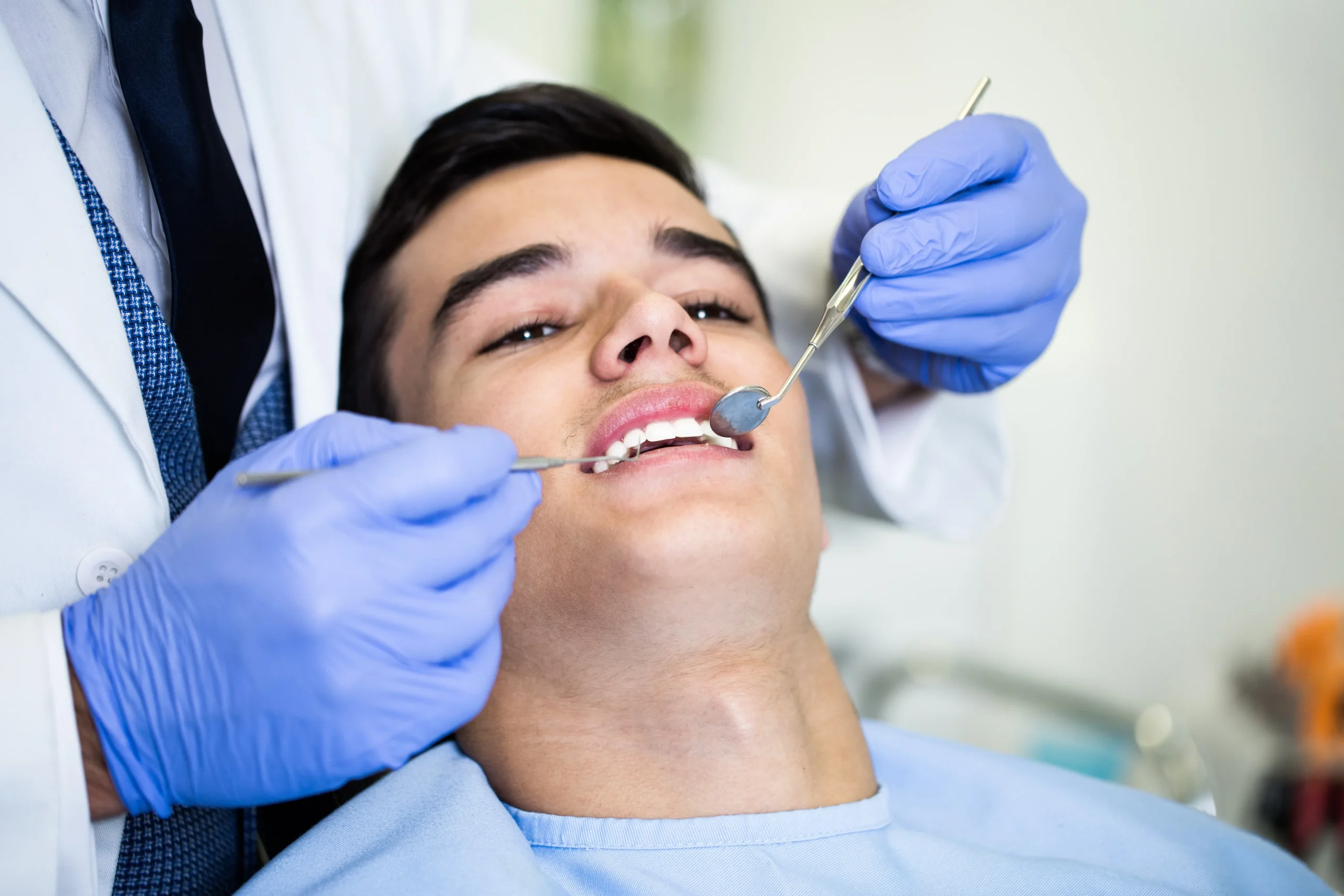 Young attractive man receiving a dental treatment. Close up shot.