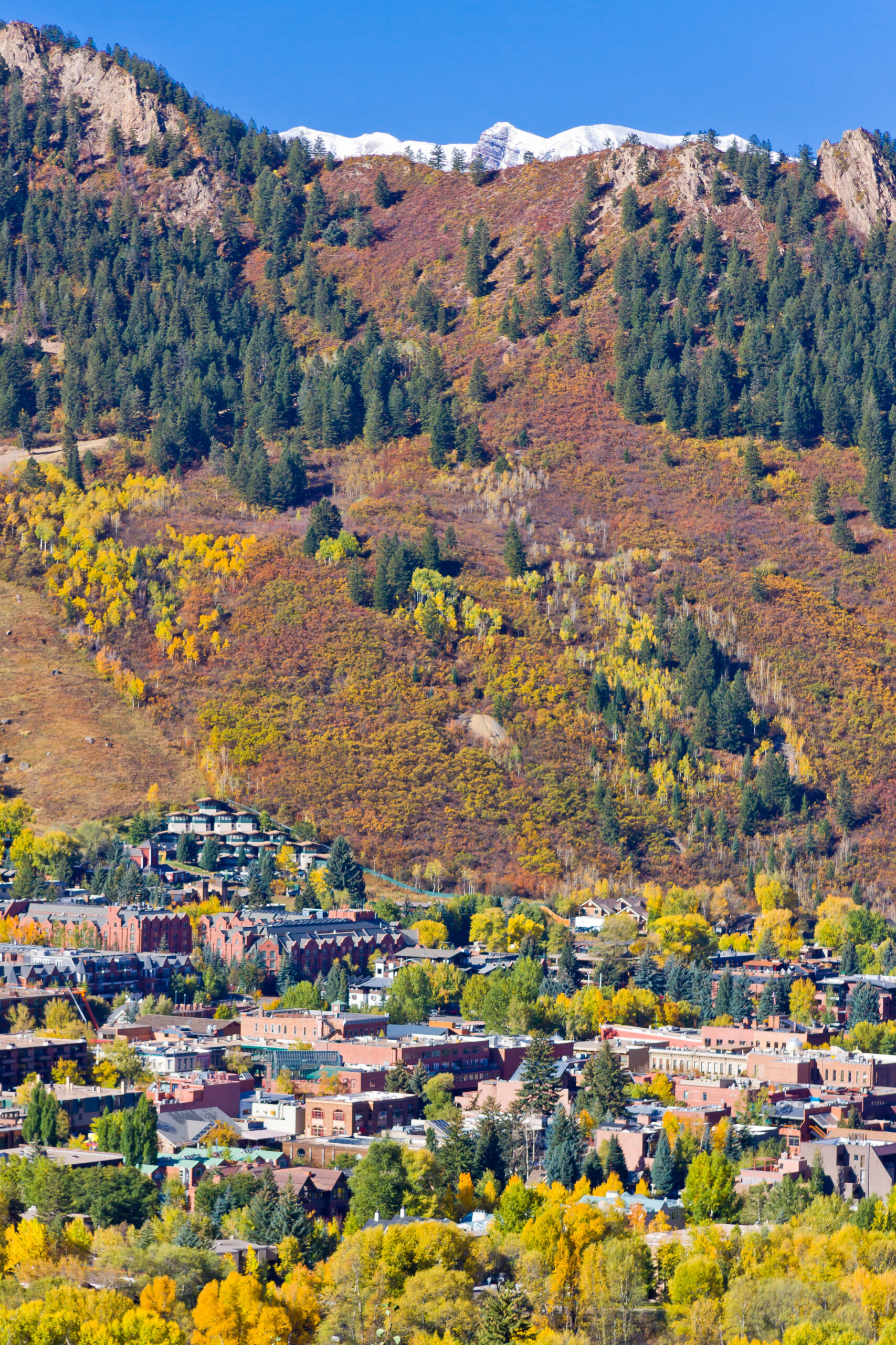 Downtown Aspen close in aerial views in Autum, with Maroon Bells barely visible in the backdrop, Pitkin County, Colorado