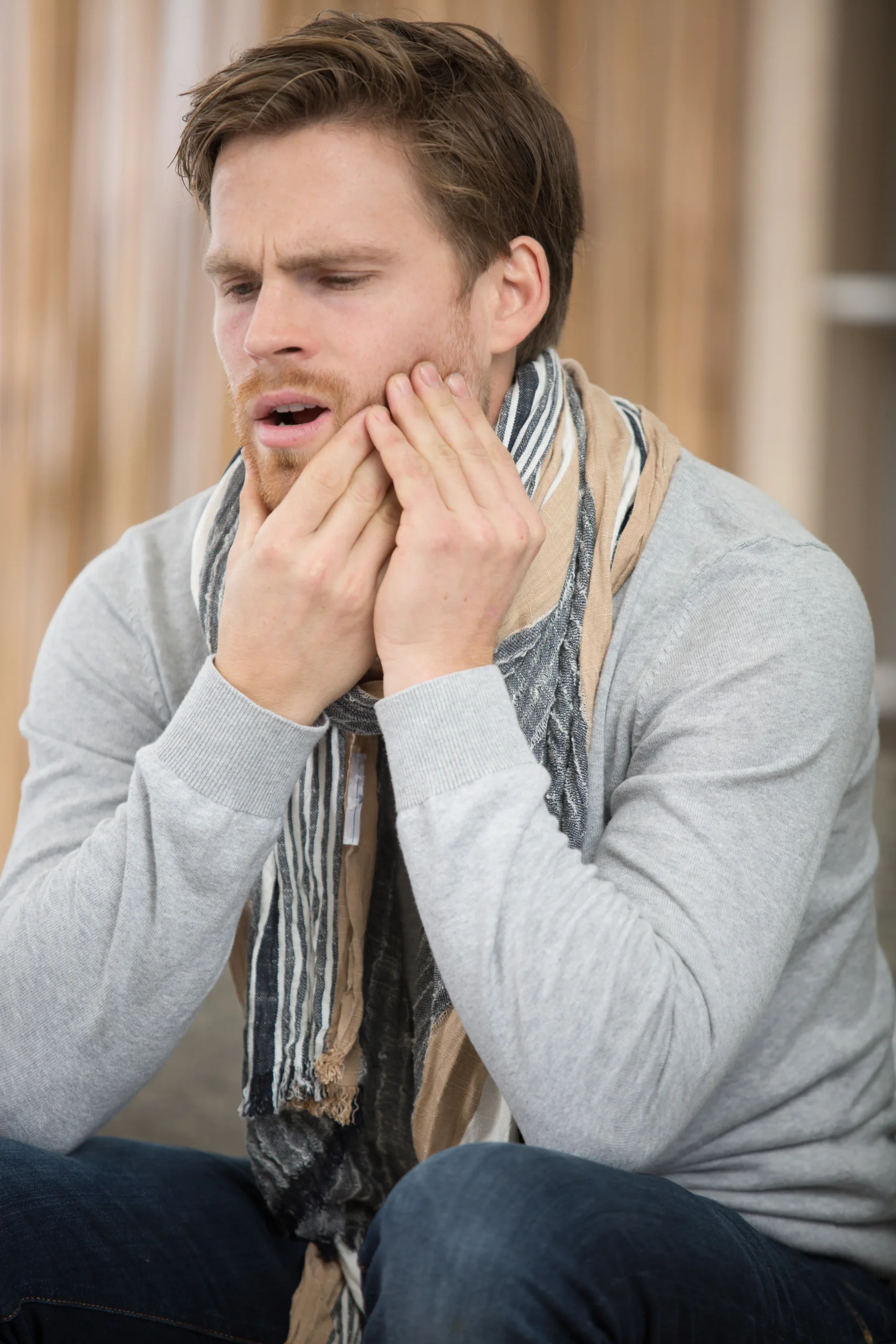 man holds his hand near the cheek toothache