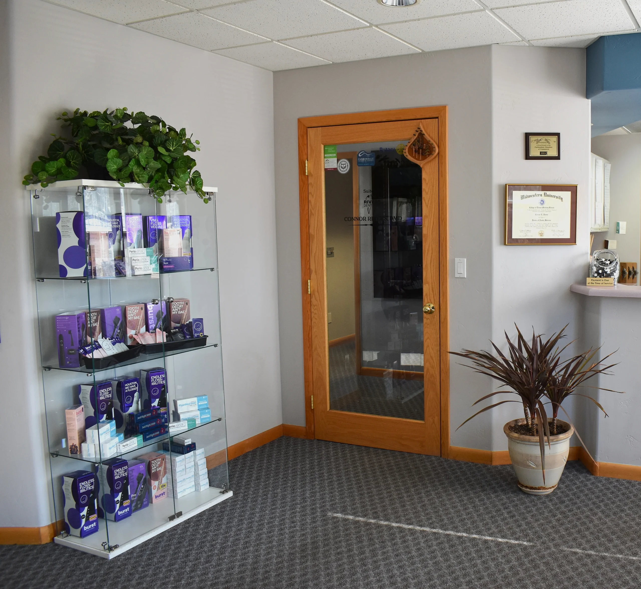 Rivers Dentistry office hallway with product display and diplomas