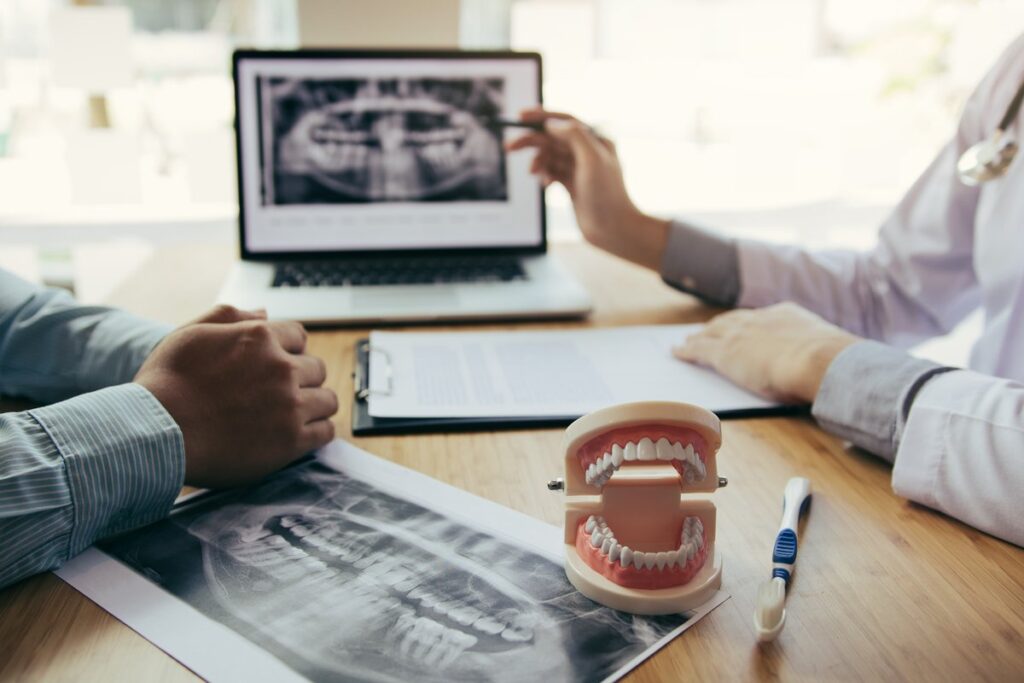 Dentist reviewing a dental x-ray with a patient to discuss a missing tooth