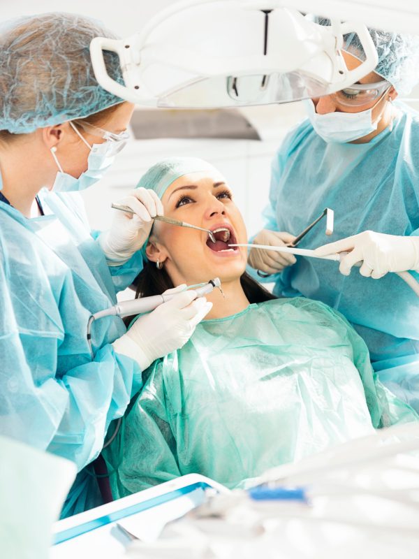 Dentists with a patient during a dental intervention.