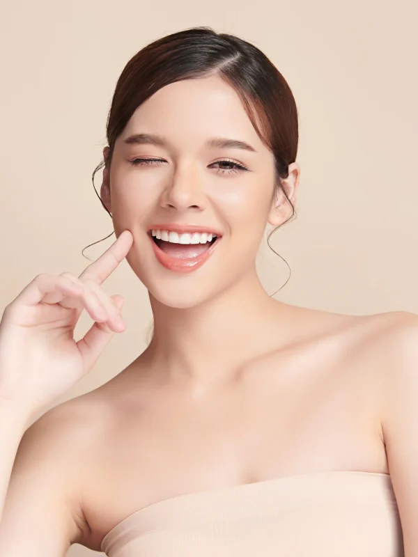 Beautiful smile young woman. White teeth on beige background,