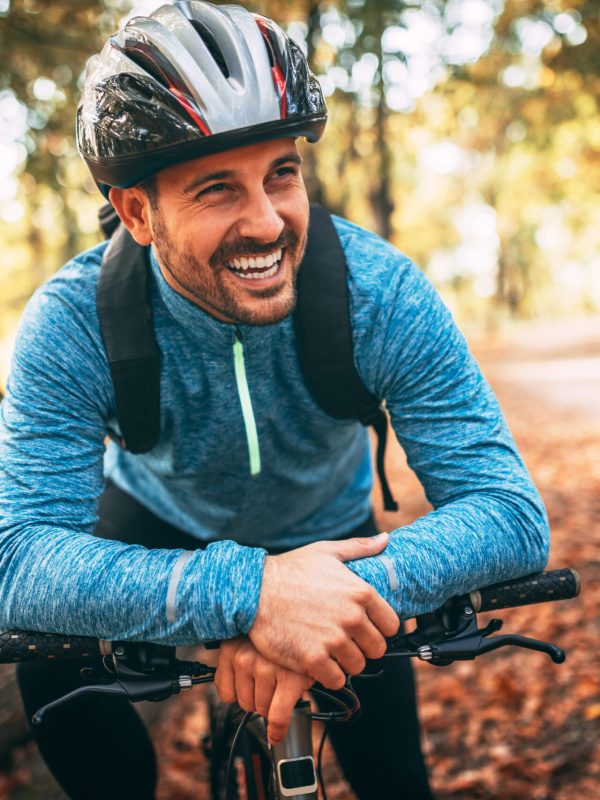 Young man biking through forest