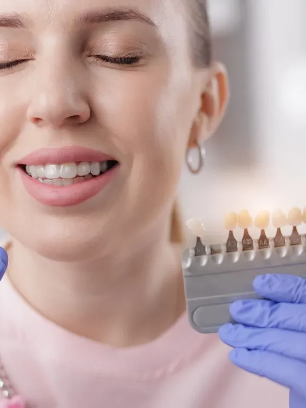 Caucasian female choosing dental veneers at dentist office.