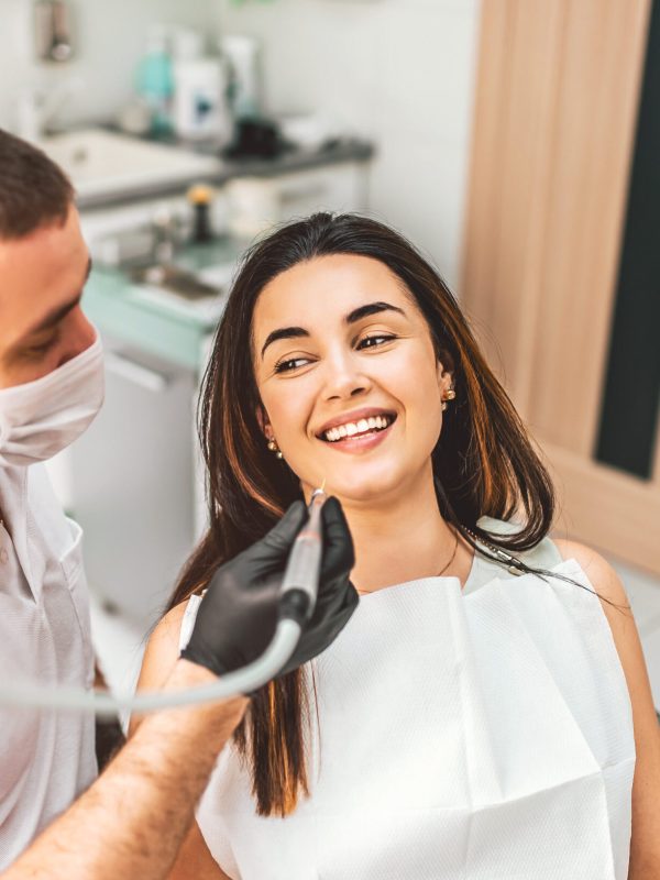 Dentist working in dental clinic with patient in the chair
