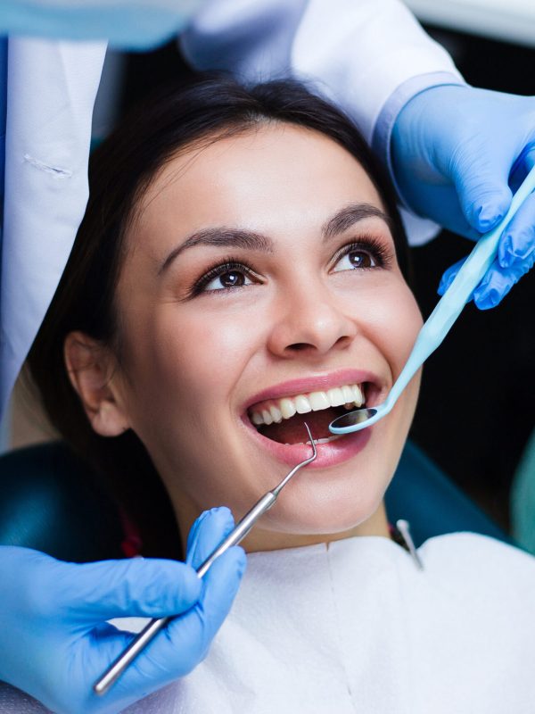 Perfect smile! Part of dentist examining his beautiful patient in dentist’s office