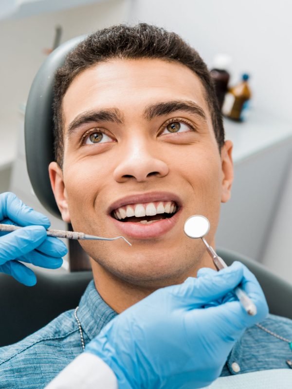 cheerful african american man with during examination in dental clinic