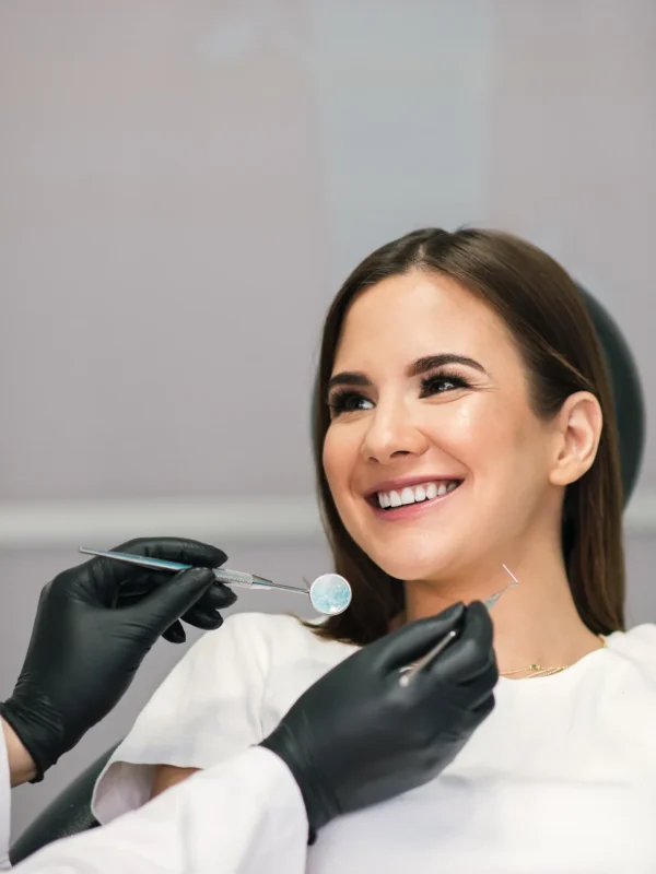 Stomatology and people concept. Female dentist working with young female patient in dental clinic.