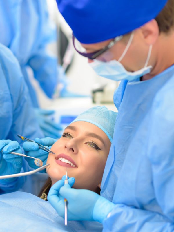 Dentist doctor and his team treating a patient at clinic