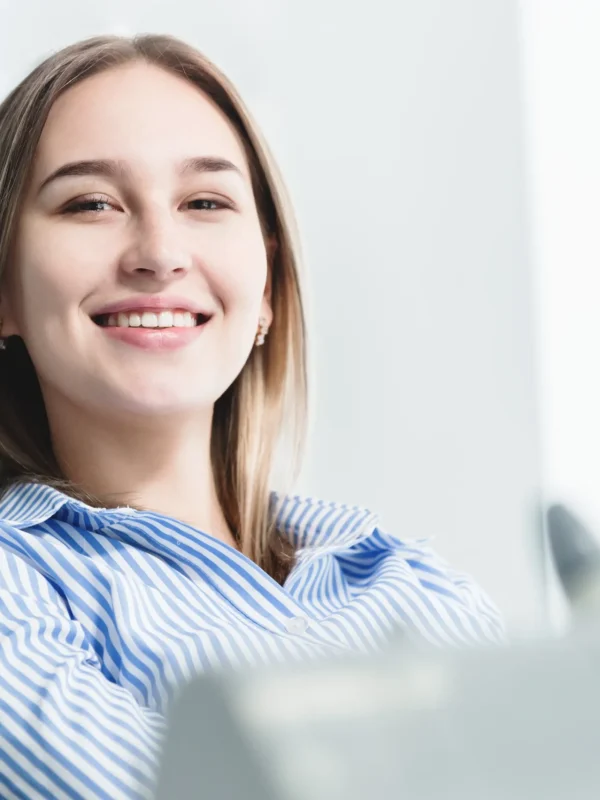 Portrait of an attractive smiling girl blonde in a dental chair. Happy customer dental cabinet.