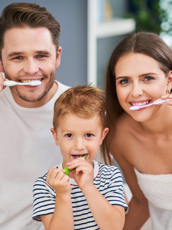 Happy family brushing teeth in the bathroom