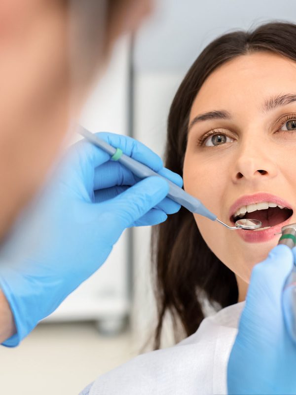 Portrait of female patient having treatment at dentist, close up