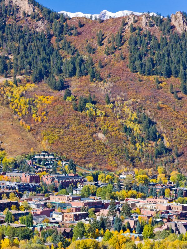 Downtown Aspen close in aerial views in Autum, with Maroon Bells barely visible in the backdrop, Pitkin County, Colorado