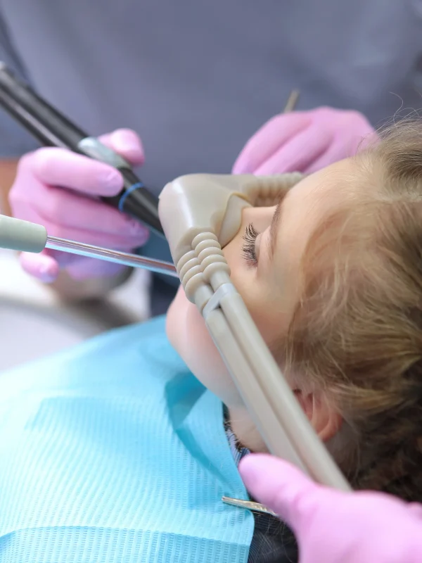 Dental treatment in a child with the use of nitrous oxide. Relaxation of the patient before surgical or dental procedures. Children's modern dentistry. The concept of healthcare.Vertical photo.