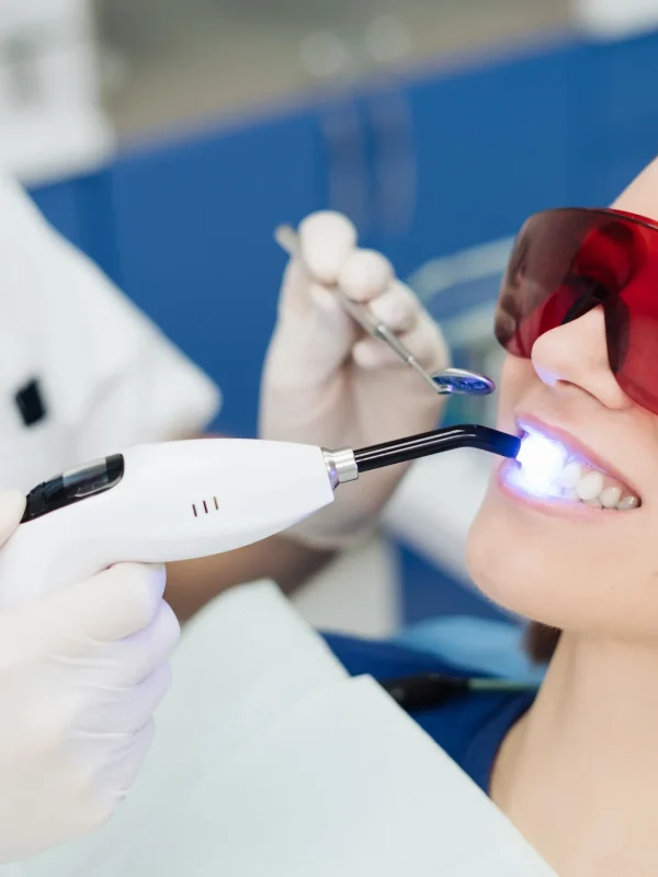 Close-up portrait of a female patient visiting dentist for teeth whitening in clinic