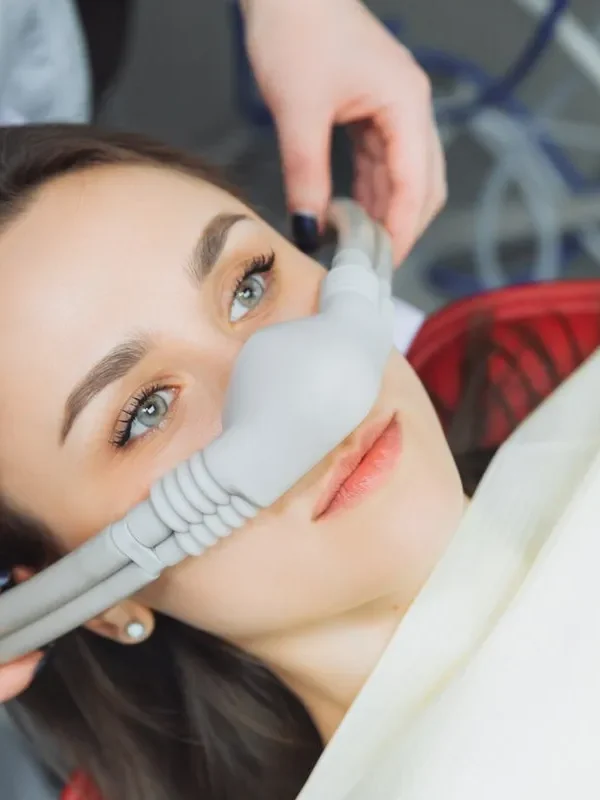 dentist puts inhalation sedative mask on his patient.
