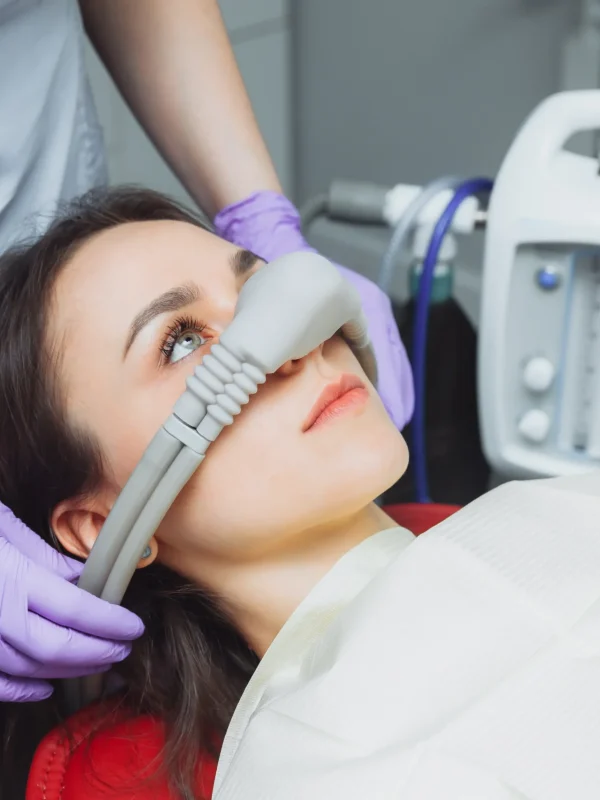 dentist puts inhalation sedative mask on his patient.