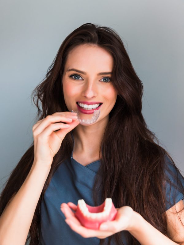 Inivisalign braces or aligner. Dentist advice how invisible orthodontics make beautiful teeth in dental clinic.