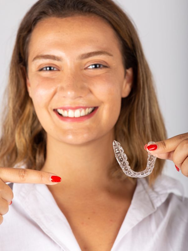 Happy young woman with invisible teeth aligner.