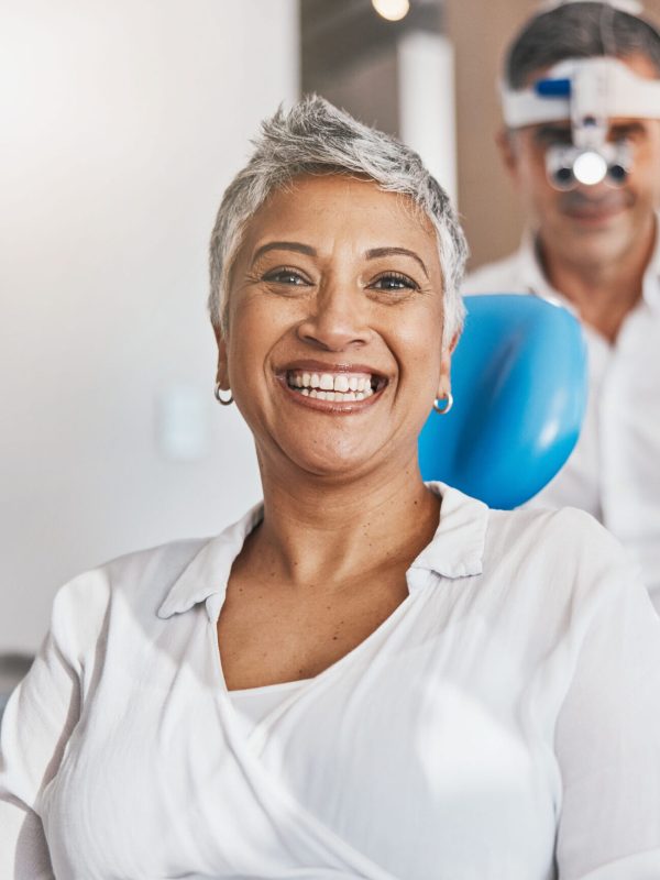 Portrait, happy and dental with a woman patient in a doctor office for oral hygiene or health. Smile, teeth and healthcare with a senior female sitting in a chair at the dentist for hygiene.