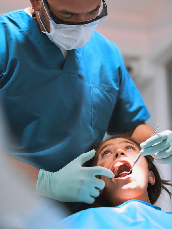 Check, child and dentist with mirror for teeth, mouth exam and oral hygiene at pediatric clinic. Girl, tools and orthodontics treatment for tooth, cleaning and cavity inspection for dental health.